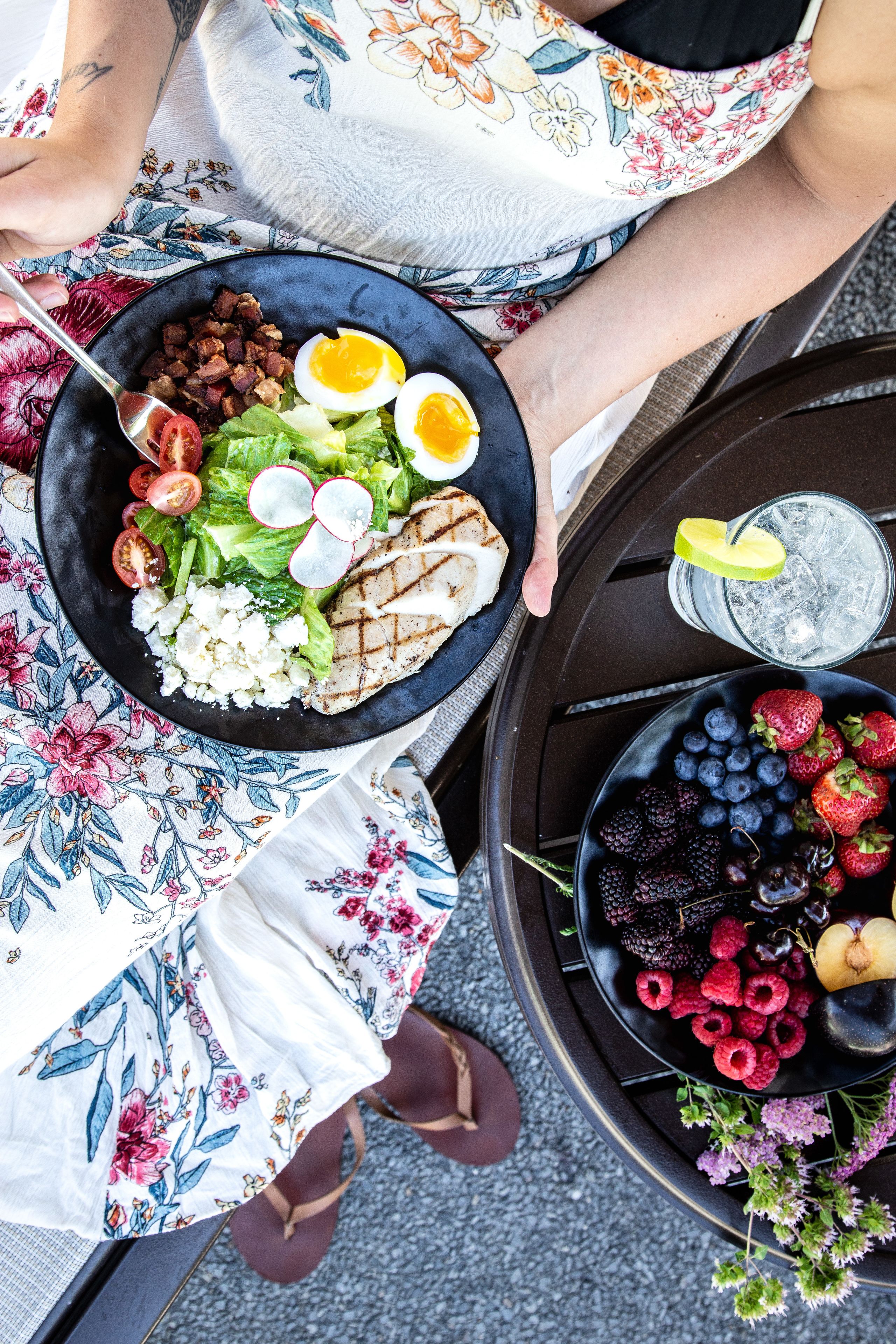 Una mesa de comedor con ensalada, carne a la parrilla y huevos.