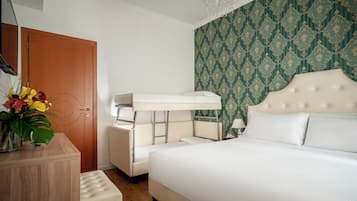 A hotel room with a bunk bed, a bedside table, a lamp, and a decorative wall.