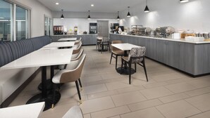 Ein modernes Restaurant mit einer langen Theke, verschiedenen Sitzgelegenheiten und einem klaren, minimalistischen Design.