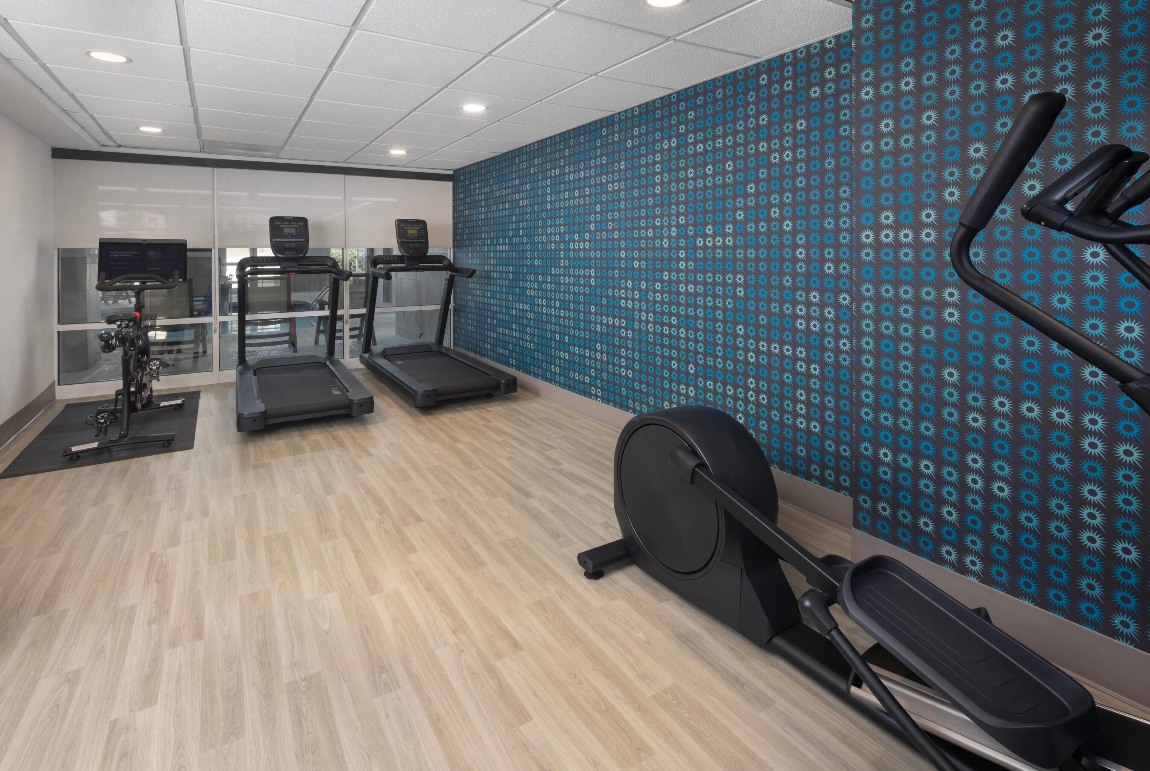 A gym with treadmills, an elliptical, and a stationary bike.