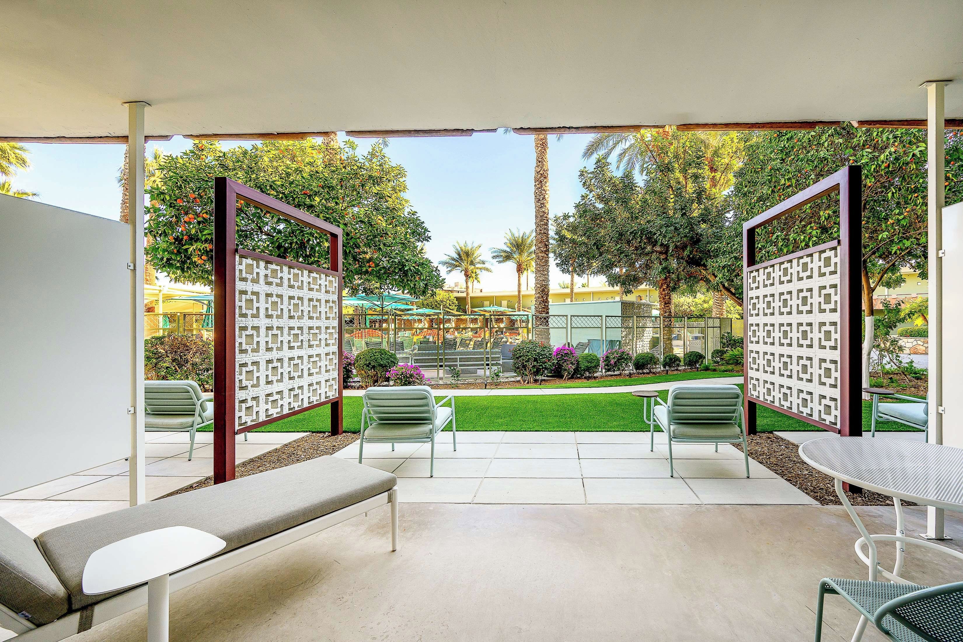 A patio area with two lounge chairs, a small table, and a decorative fence.
