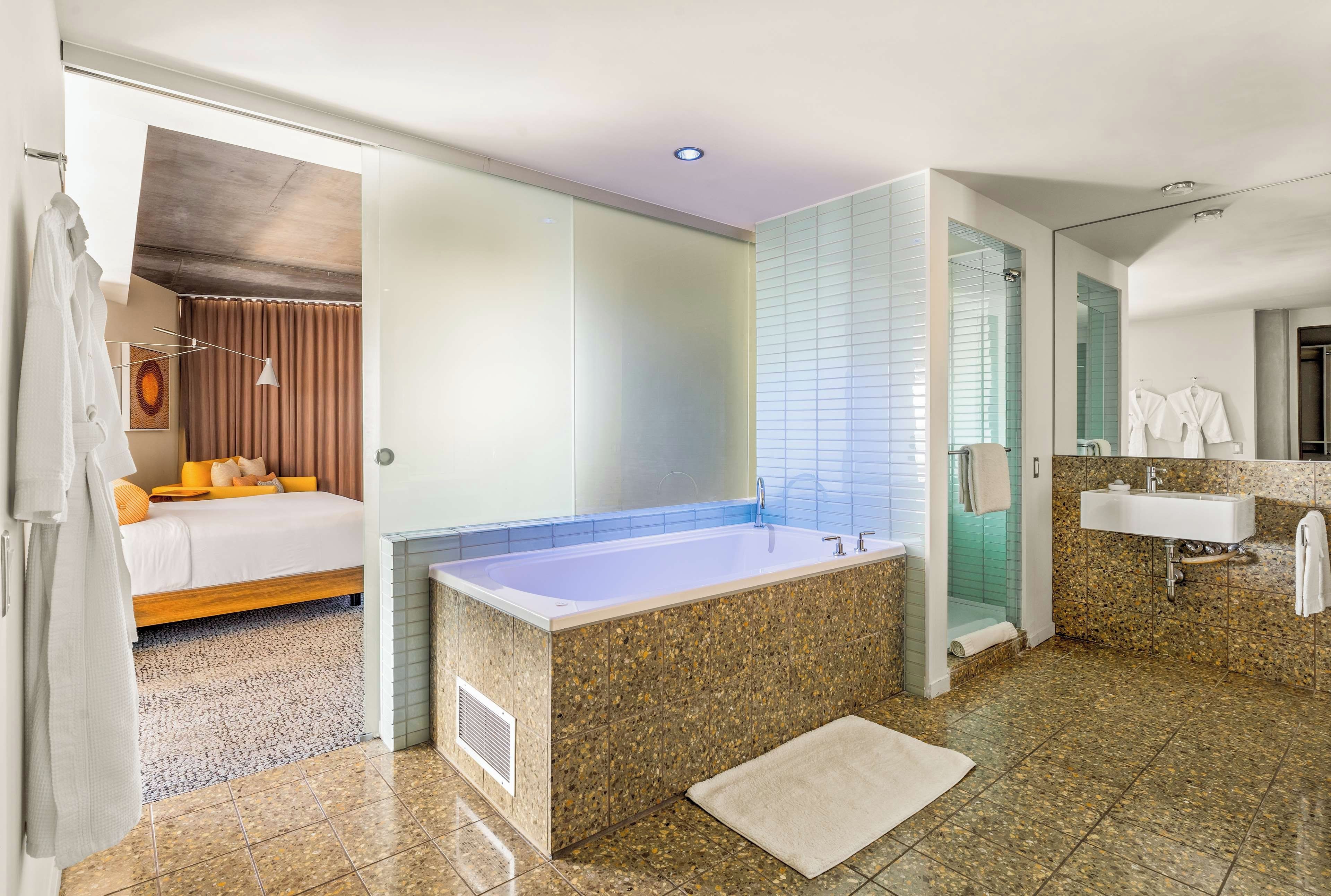 A modern bathroom with a large bathtub, a separate shower area, and a vanity with a sink.