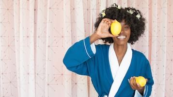 A person in a blue robe holding a lemon.