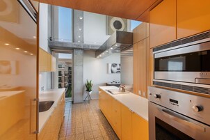 Una cocina moderna con electrodomésticos de acero inoxidable, una isla central y vistas al interior del edificio.