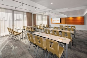 A conference room with multiple tables and chairs, a whiteboard, and a large wooden panel on the wall. - Hotel Valley Ho (Scottsdale)