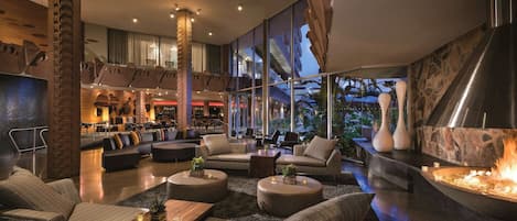 Un área de descanso moderna con asientos, bar y chimenea.
