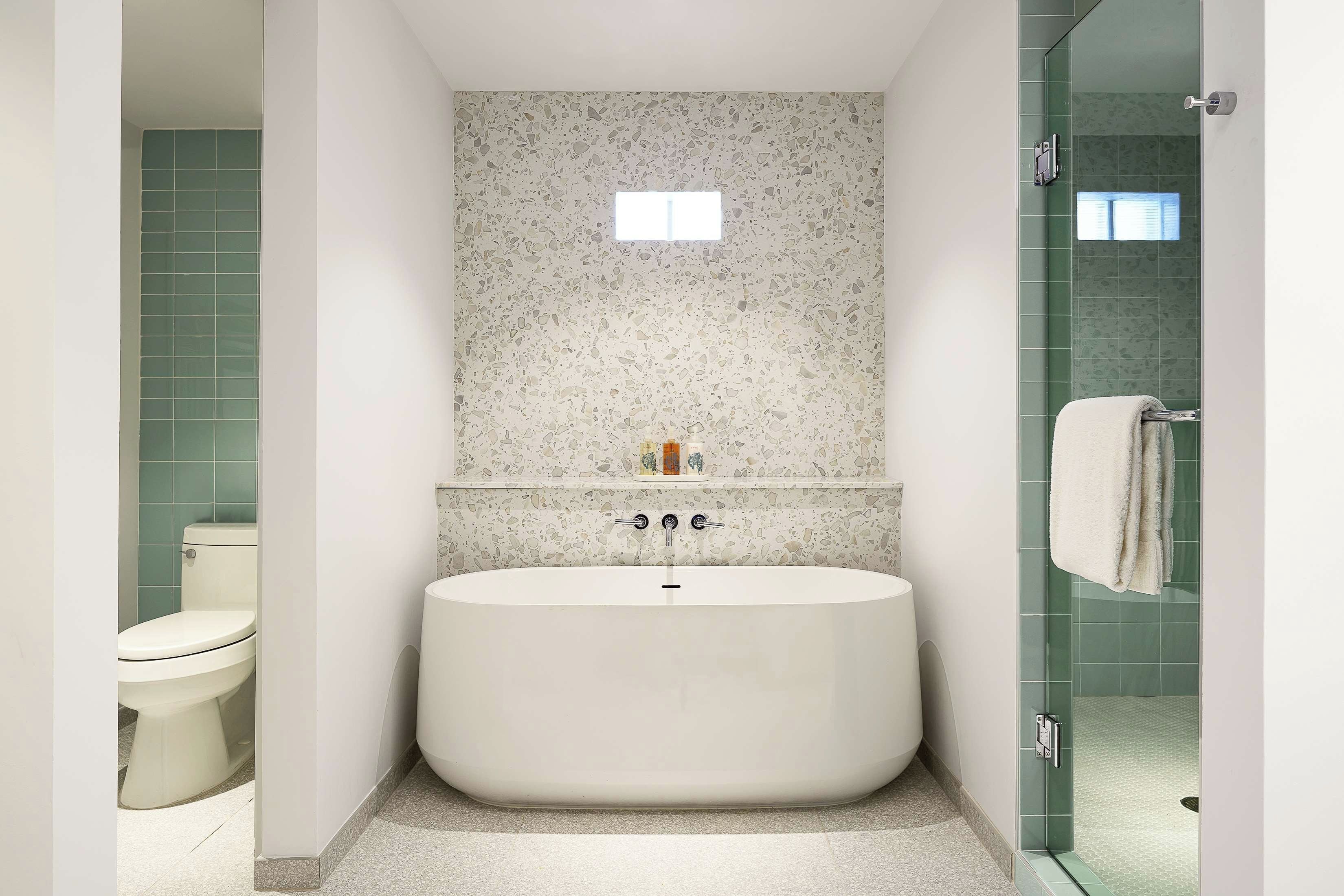 Ein modernes Badezimmer mit einer freistehenden Badewanne, einer Toilette und einer Duschkabine aus Glas.