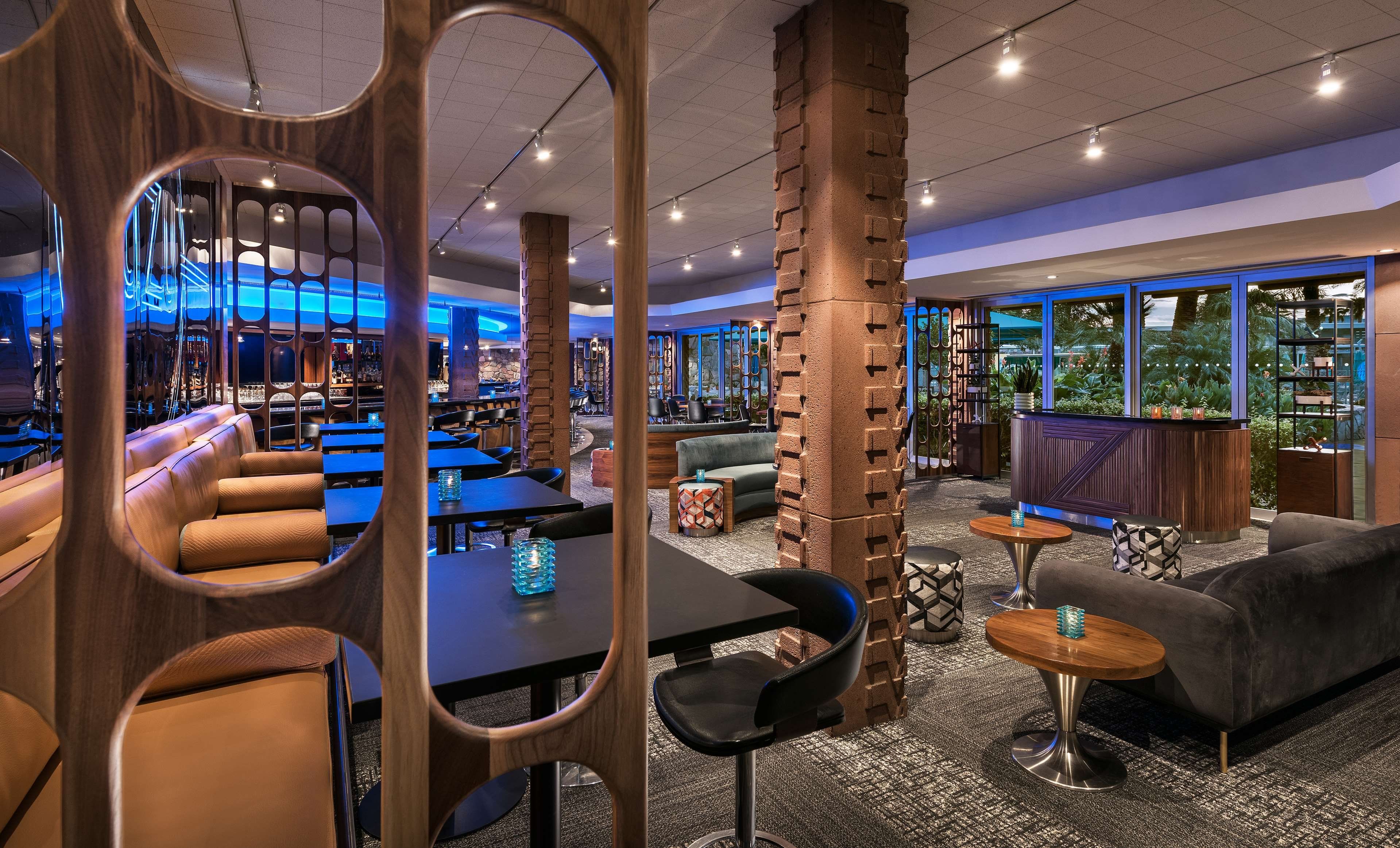 A modern interior with seating areas, a bar, and large windows.
