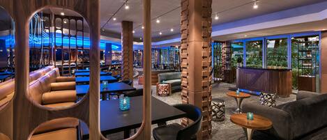 A modern interior with seating areas, a bar, and large windows.
