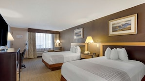 A hotel room with two beds, a desk, a chair, a lamp, a telephone, and a painting on the wall. - Best Western Smoky Mountain Inn (Waynesville)