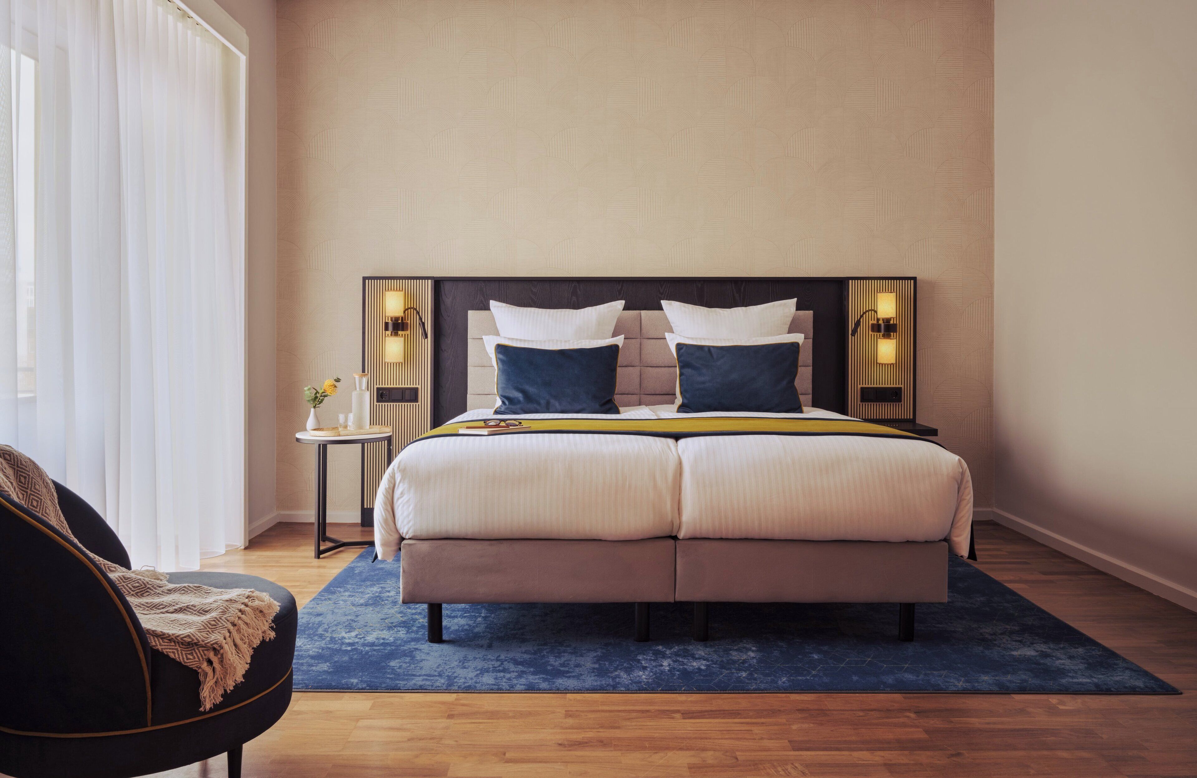 Un dormitorio con una cama grande, dos mesitas de noche y una silla.
