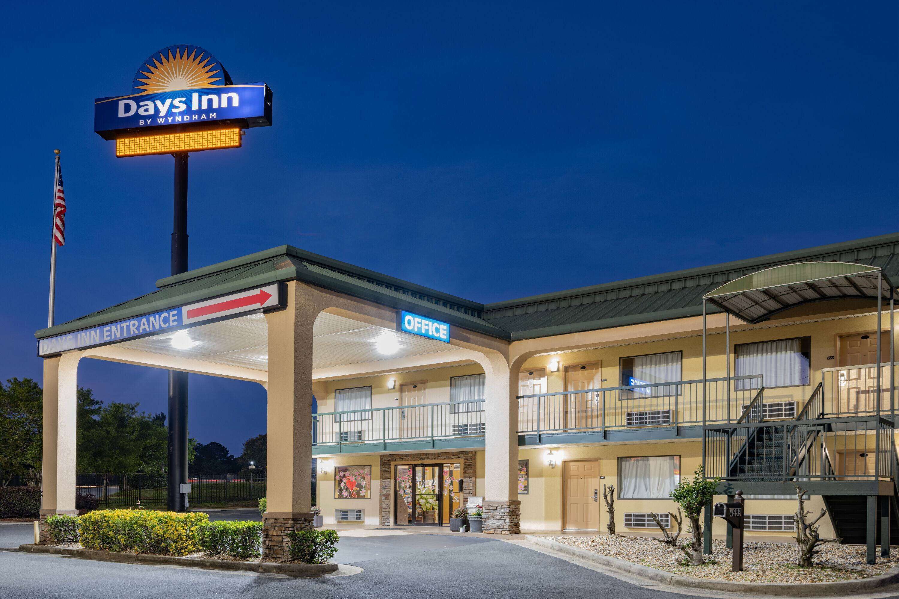 A Days Inn by Wyndham with a clear entrance, office, and a two-story building with balconies.