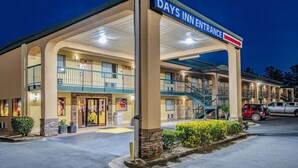 Entrada de un Days Inn con un corredor cubierto, varios balcones y un estacionamiento.