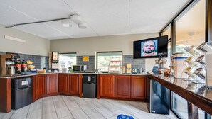 A modern kitchen with wooden cabinets, a built-in microwave, and a large window. - Days Inn by Wyndham Nashville Saint Thomas West Hospital (Nashville)