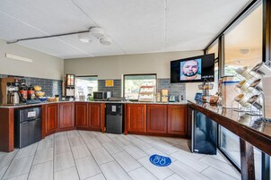A modern kitchen with wooden cabinets, a built-in microwave, and a large window.