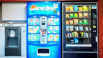 Una máquina expendedora con el logotipo de Pepsi, rodeada de otras máquinas expendedoras.