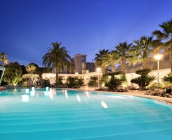 Una piscina al aire libre, sillones reclinables de piscina