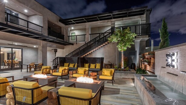 Un espace extérieur aménagé avec une terrasse, des sièges et un foyer.