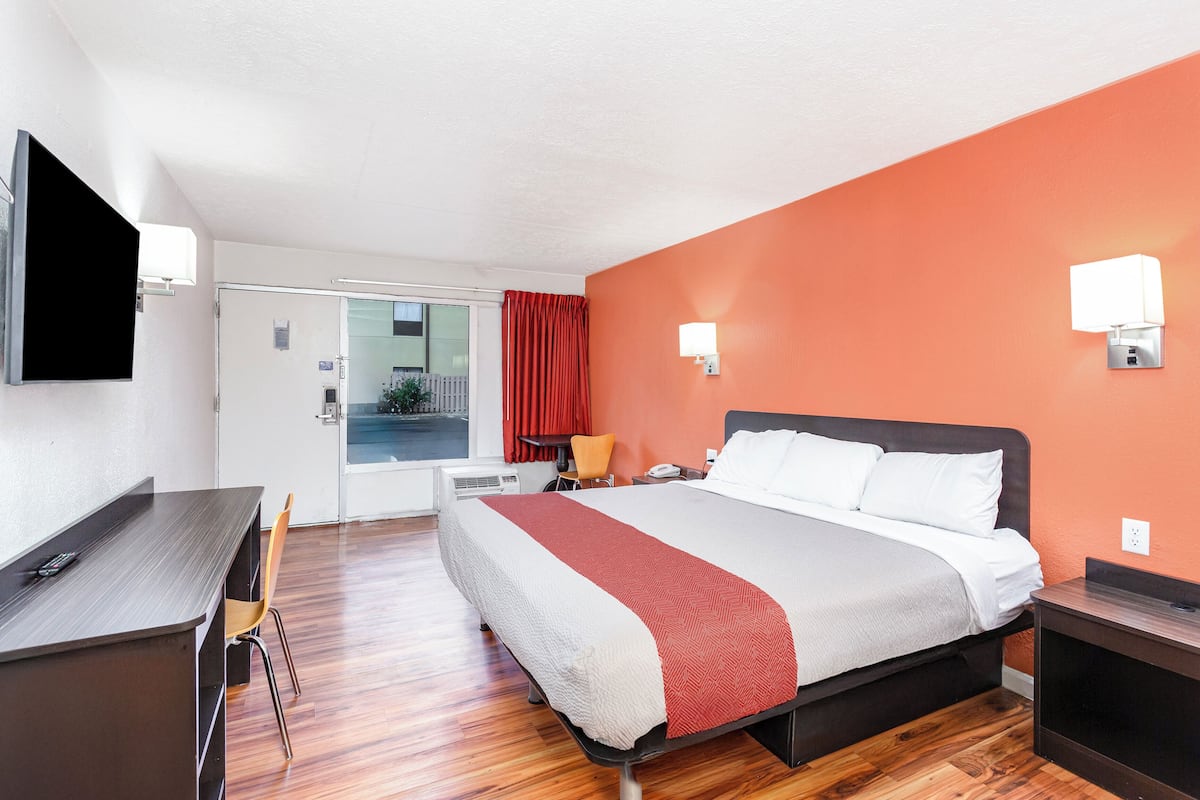 A hotel room with a bed, desk, and chair.