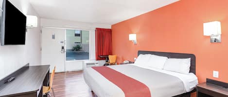 A hotel room with a bed, desk, and chair.