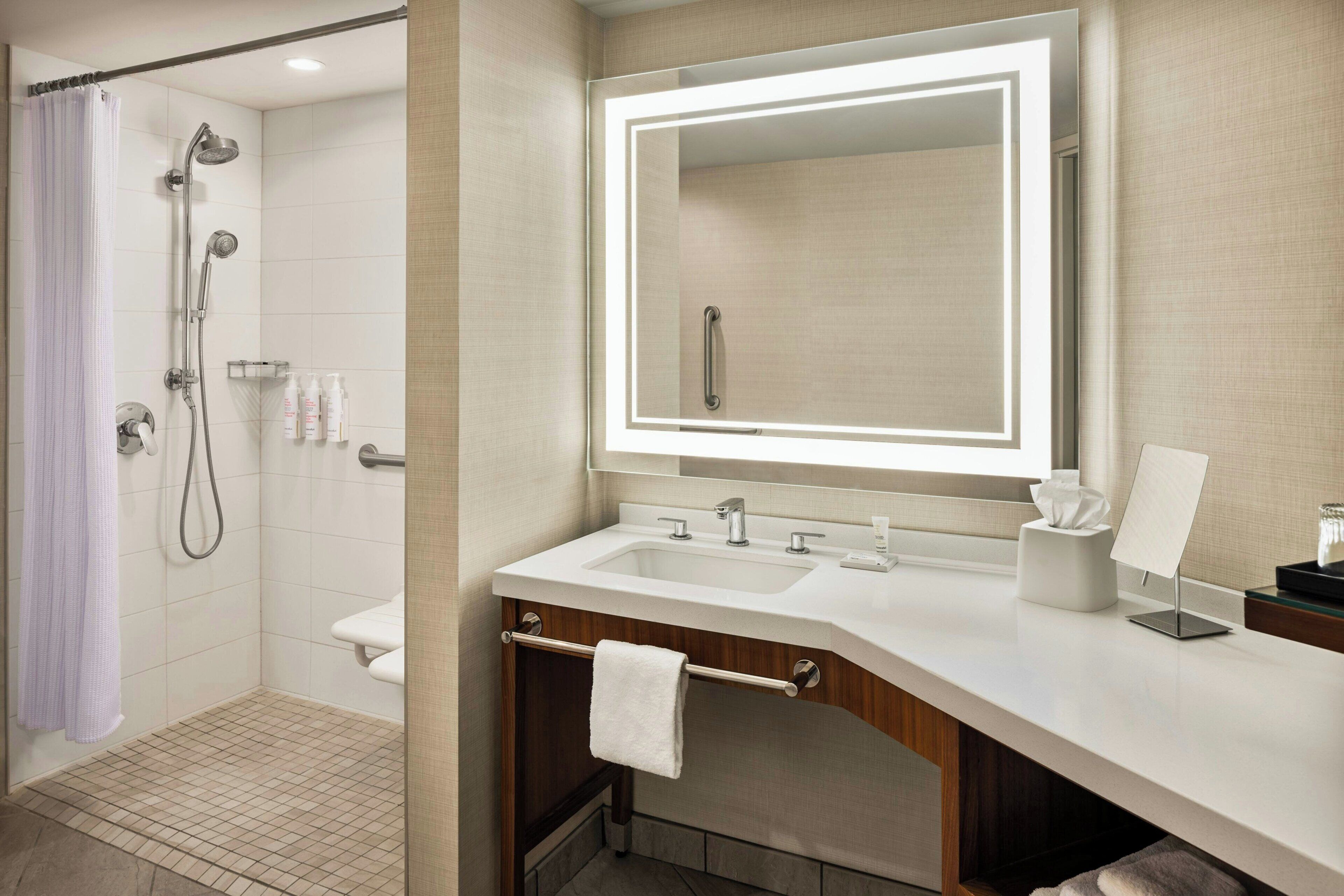 A bathroom with a shower, toilet, and vanity with a mirror.