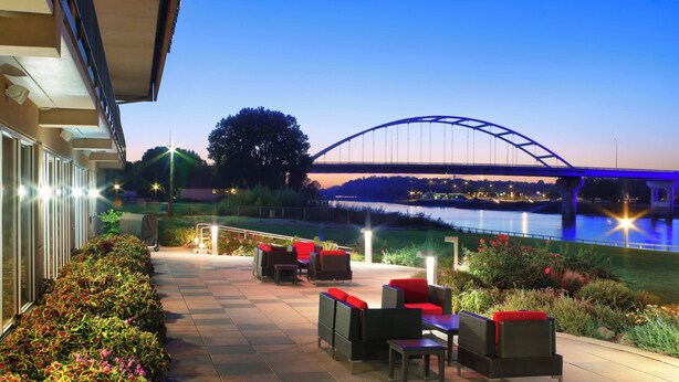 Un patio al aire libre con asientos y vistas a un puente.