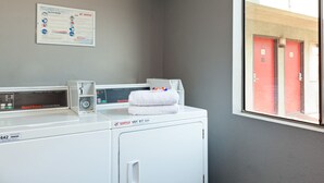 A laundry area with a washing machine, dryer, and a wall-mounted instruction manual.