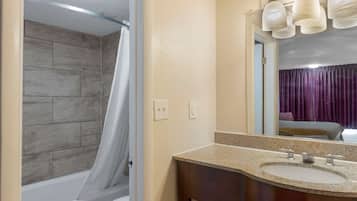 Escritorio, cortinas blackout y tabla de planchar con plancha