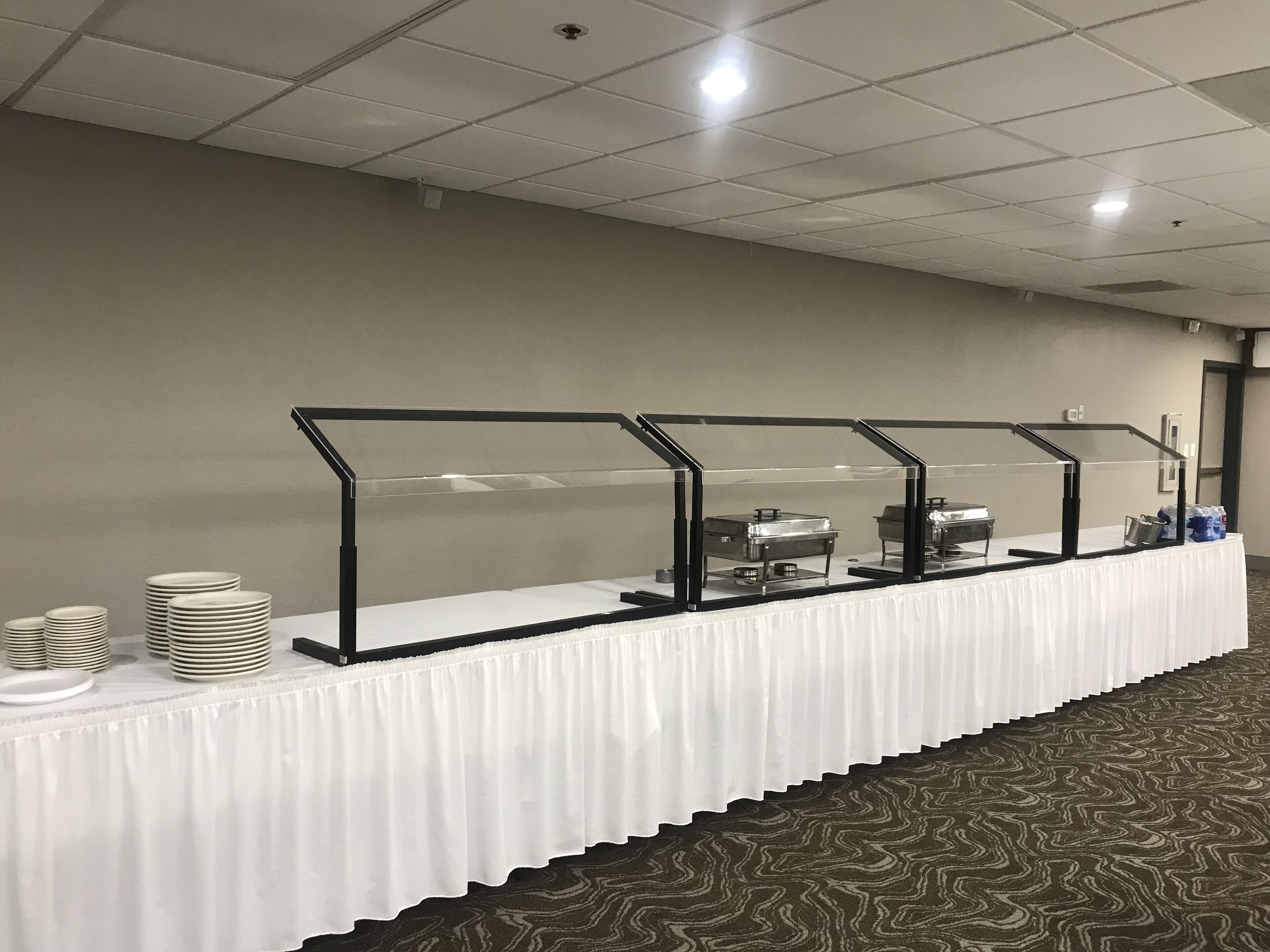 Un buffet organizzato con appositi separatori e una tovaglia bianca.