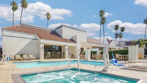 A swimming pool with a hot tub, lounge chairs, and palm trees. - Best Western Plus Big America (Santa Maria)