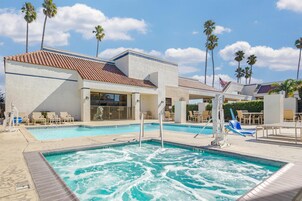 Una piscina al aire libre, sillones reclinables de piscina