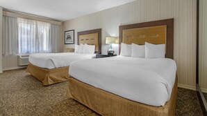 A hotel room with two beds, a large window with curtains, a framed picture on the wall, and a lamp on the nightstand. - Best Western Plus Big America (Santa Maria)