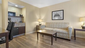 A hotel room with a kitchenette, a sofa, a coffee table, and a framed picture on the wall. - Best Western Plus Big America (Santa Maria)