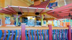 Ein lebhaftes Restaurant mit farbenfroher Architektur, darunter ein auffälliges Dach und geschwungene Geländer.