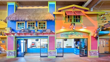 A colorful building with a thatched roof and a sign reading "Gators Grab & Go".