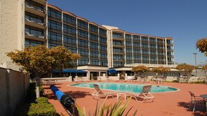Un hôtel doté d’une piscine, d’un espace extérieur aménagé et d’un grand bâtiment comportant de nombreux balcons.