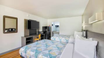 Une chambre d’hôtel avec deux lits, une télévision, un bureau et un miroir.