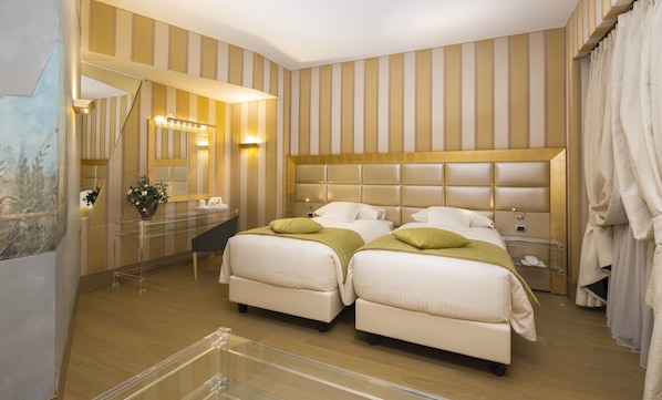 Una habitación de hotel con dos camas, un tocador con espejo y un ventanal con cortinas.