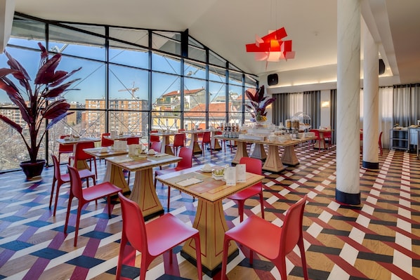 Un restaurant moderne avec de grandes fenêtres, des chaises rouges et un sol à motifs.