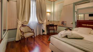 Una camera d'albergo con un letto, una sedia, una scrivania e uno specchio.