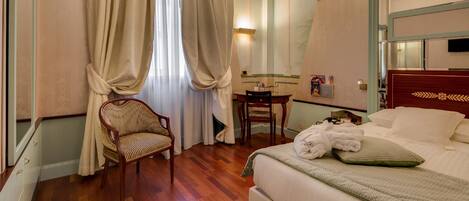 Una habitación de hotel con cama, una silla, un escritorio y un espejo.