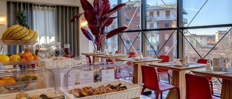A breakfast buffet with various food items and a large window view.