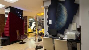 A modern office space with a desk, chairs, and a large abstract wall art piece.