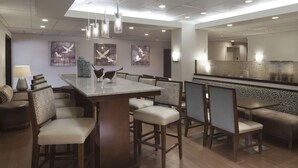 Un comedor moderno con una isla central, diversas opciones de asientos y obras de arte en las paredes.