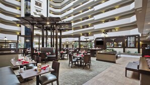 A multi-level restaurant with dining tables, chairs, and a bar area.