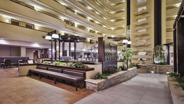 A spacious lobby with a reception desk, seating area, and a Gold Bison Grill.