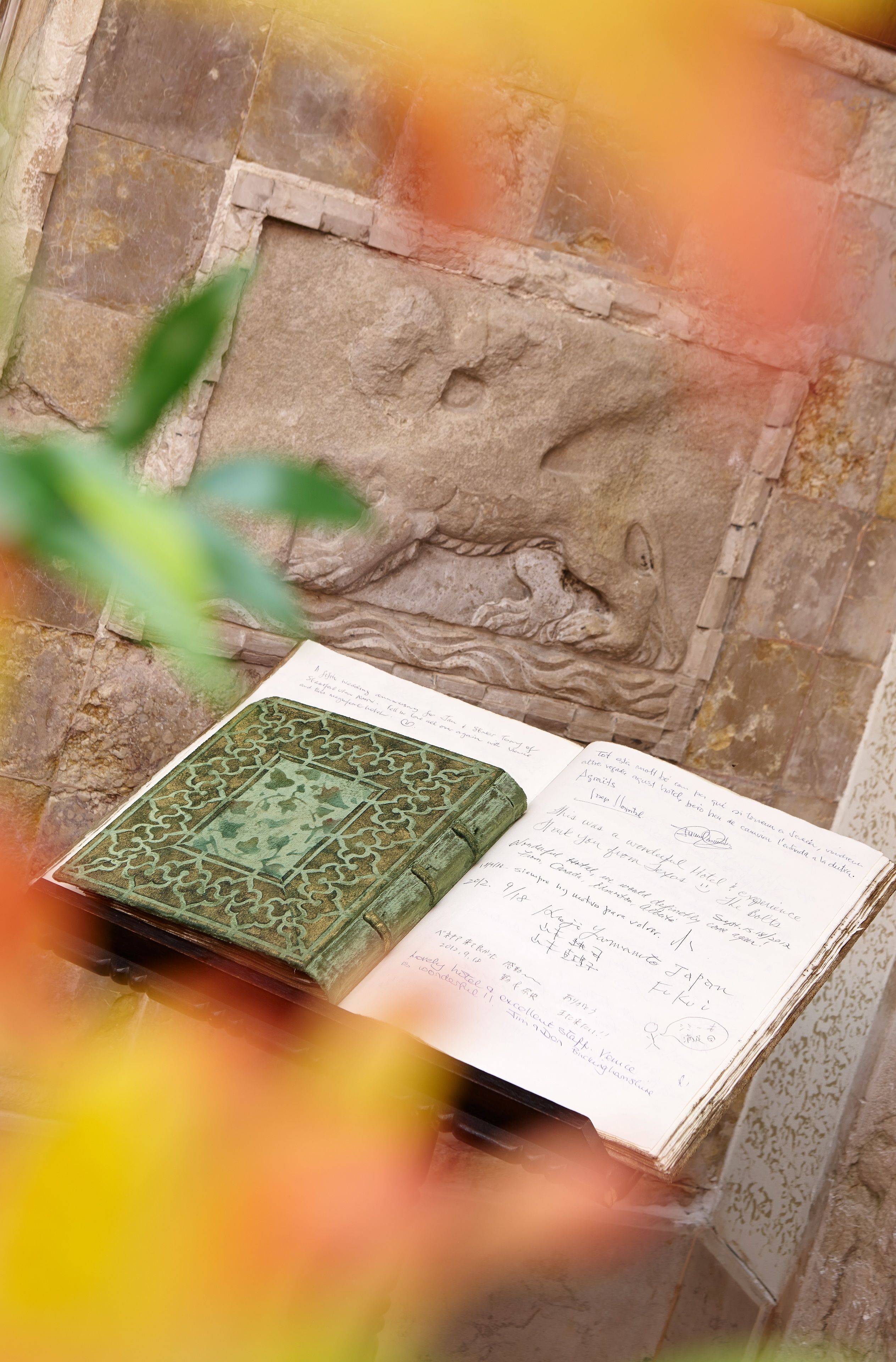 A book with handwritten notes on a stone wall.