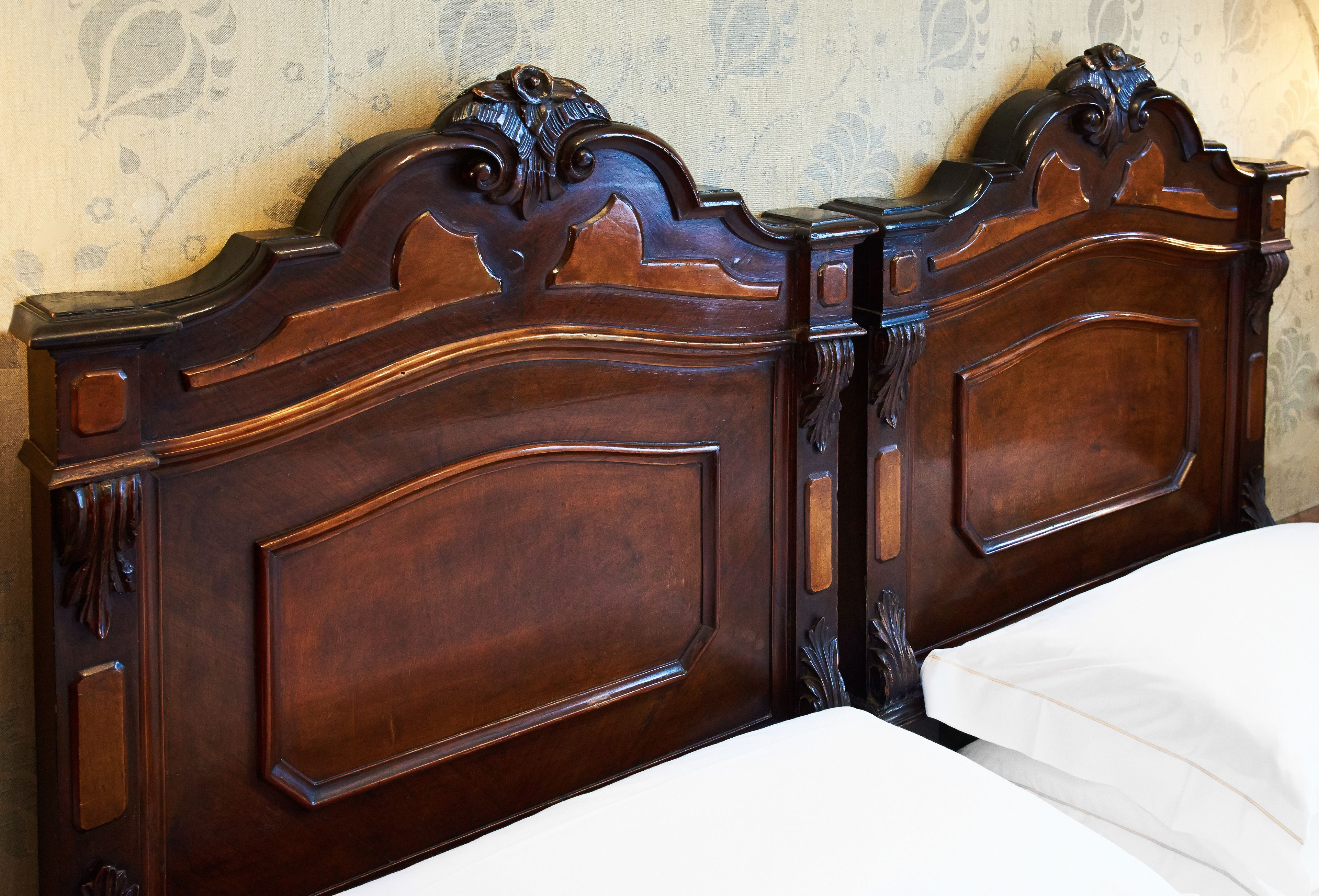 Estructura de cama de madera con intrincados grabados y un colchón blanco.