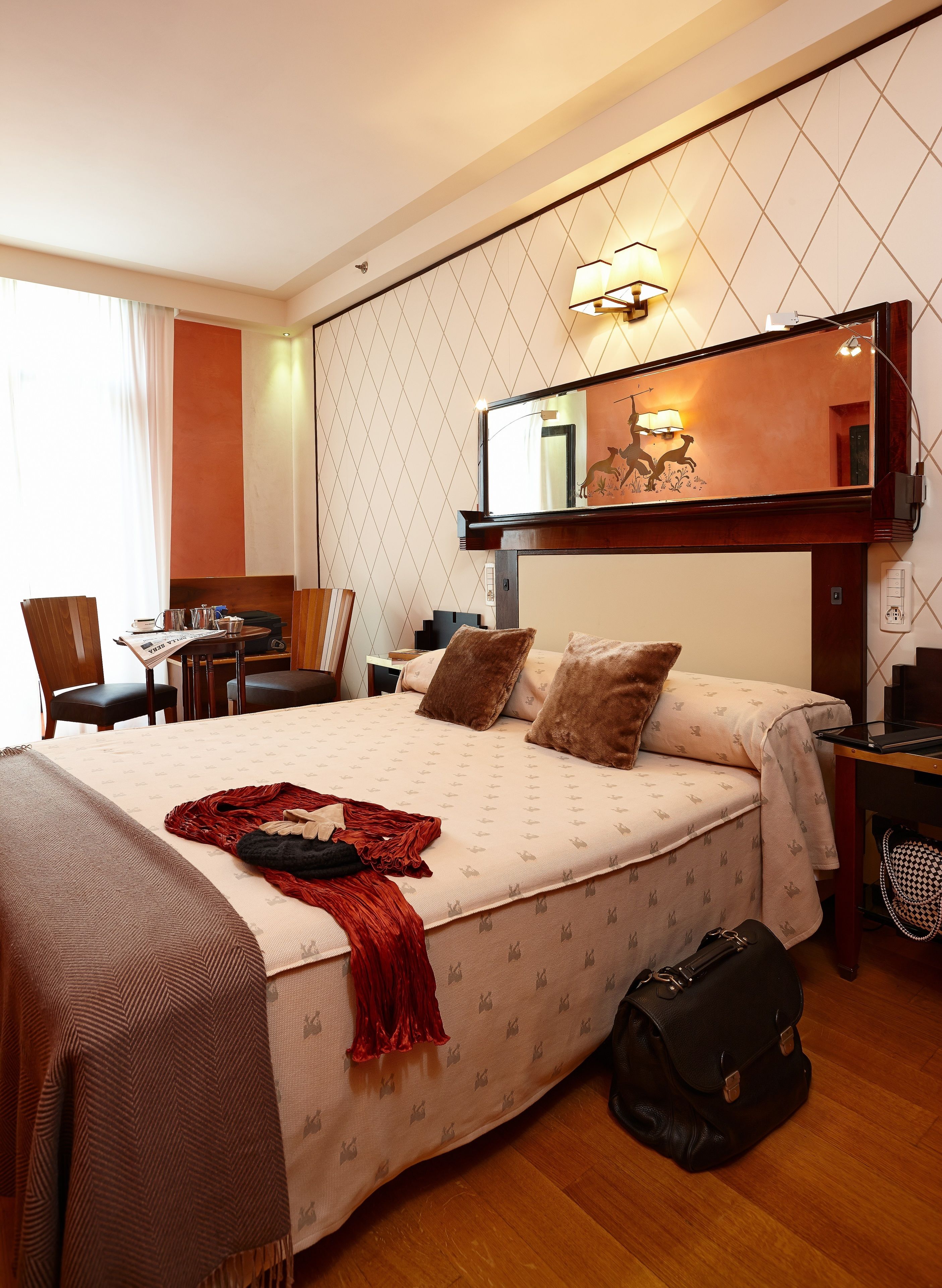 A hotel room with a bed, a desk, and a chair.