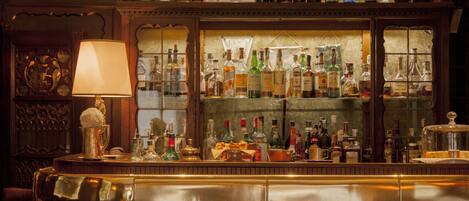 A bar with a variety of liquor bottles, a lamp, and a clock.